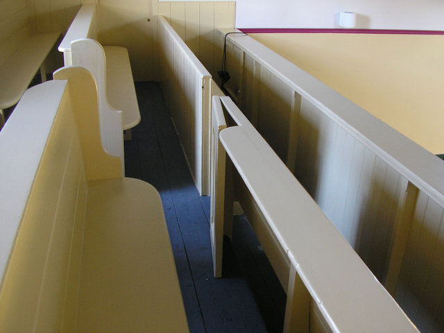 The balcony features original, church-style, pews.
